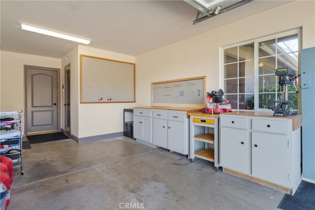 garage featuring a workshop area and baseboards