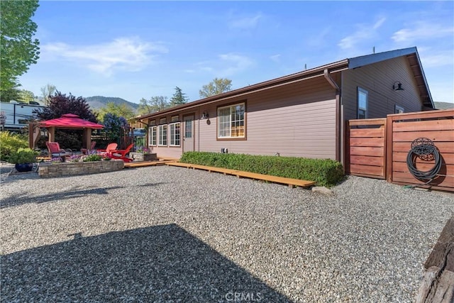 view of front of house with a mountain view, fence, and a patio