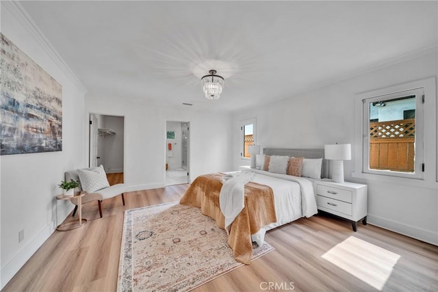 932 S Cloverdale Ave, Los Angeles, CA 90036 - bedroom with light wood finished floors, crown molding, a chandelier, baseboards, and ensuite bath