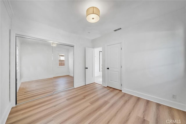 932 S Cloverdale Ave, Los Angeles, CA 90036 - unfurnished bedroom with wood finished floors, baseboards, and a closet