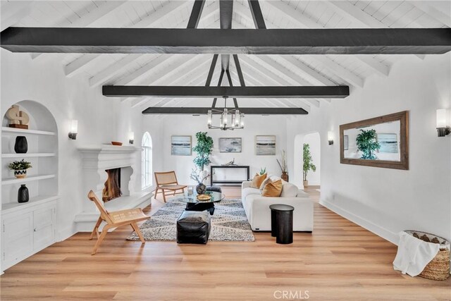 932 S Cloverdale Ave, Los Angeles, CA 90036 - living room featuring arched walkways, a lit fireplace, a chandelier, light wood finished floors, and wooden ceiling