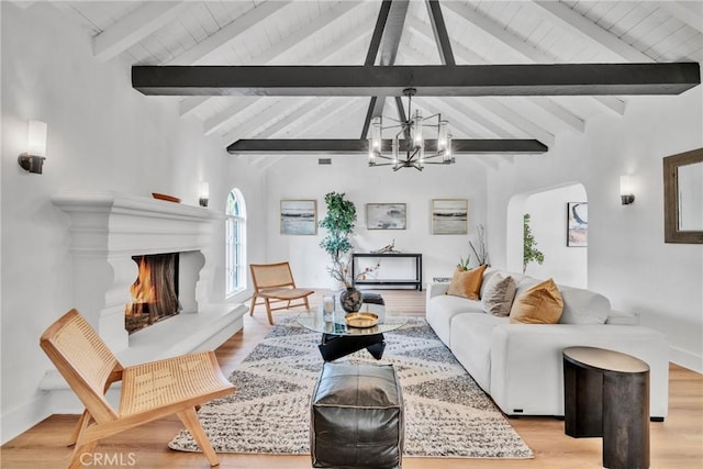 932 S Cloverdale Ave, Los Angeles, CA 90036 - living room featuring a chandelier, light wood-style flooring, wood ceiling, arched walkways, and a lit fireplace