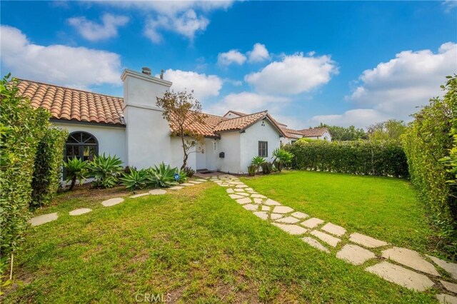 932 S Cloverdale Ave, Los Angeles, CA 90036 - rear view of property with a yard, a chimney, a tile roof, and stucco siding