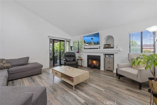 13429 Benbow St, Baldwin Park, CA 91706 - living room featuring a warm lit fireplace, high vaulted ceiling, wood finished floors, and baseboards
