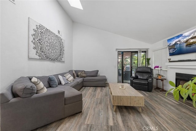 13429 Benbow St, Baldwin Park, CA 91706 - living area featuring wood finished floors, a fireplace, high vaulted ceiling, and a skylight