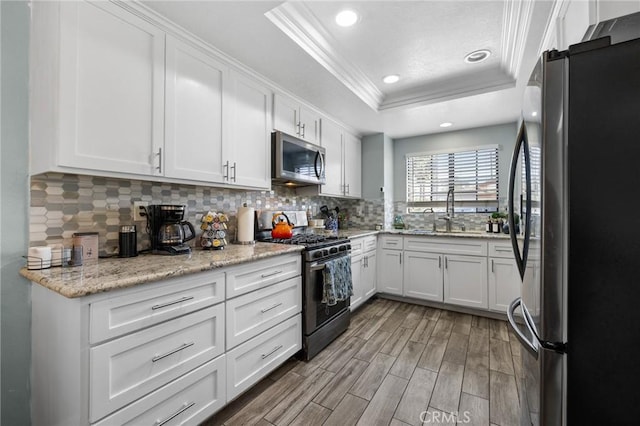 13429 Benbow St, Baldwin Park, CA 91706 - kitchen featuring stainless steel appliances, a raised ceiling, crown molding, a sink, and wood finished floors