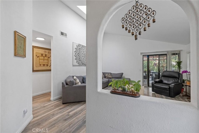 13429 Benbow St, Baldwin Park, CA 91706 - corridor with arched walkways, high vaulted ceiling, wood finished floors, baseboards, and a skylight