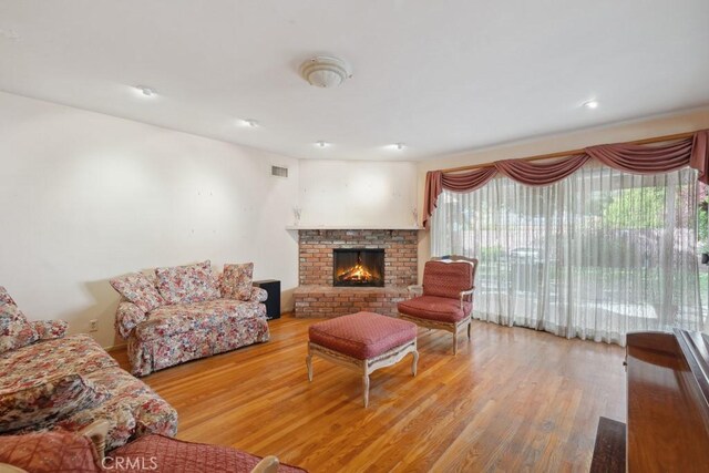 7861 Cora St, Sunland, CA 91040 - living room featuring a brick fireplace and wood finished floors
