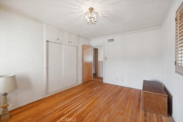 7861 Cora St, Sunland, CA 91040 - unfurnished bedroom featuring light wood finished floors, a chandelier, and a closet