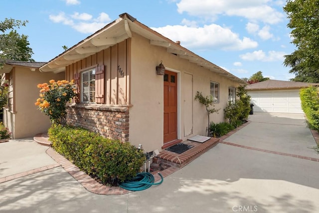7861 Cora St, Sunland, CA 91040 - view of side of property with a garage, an outdoor structure, stucco siding, and concrete driveway