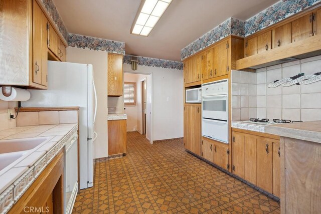 7861 Cora St, Sunland, CA 91040 - kitchen with tile countertops, dark floors, a warming drawer, white appliances, and brown cabinetry