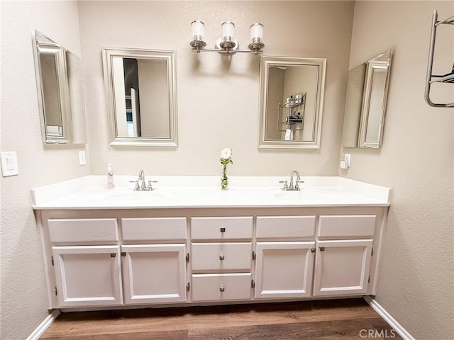 26490 Mapleridge Way, Moreno Valley, CA 92555 - bathroom featuring double vanity, wood finished floors, baseboards, and a textured wall