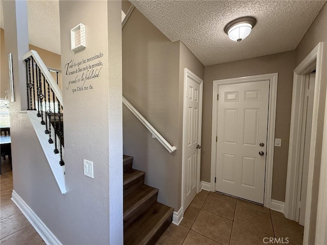 26490 Mapleridge Way, Moreno Valley, CA 92555 - entrance foyer with a textured ceiling, stairway, tile patterned flooring, and baseboards