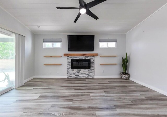 27533 Caraway Ln, Saugus, CA 91350 - unfurnished living room featuring plenty of natural light, a glass covered fireplace, wood finished floors, and crown molding