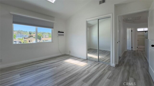 27533 Caraway Ln, Saugus, CA 91350 - unfurnished bedroom featuring a closet, an AC wall unit, wood finished floors, and lofted ceiling
