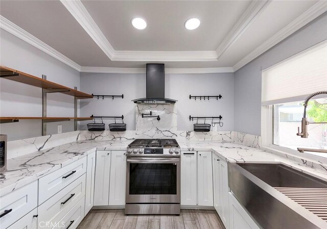 27533 Caraway Ln, Saugus, CA 91350 - kitchen featuring stainless steel gas stove, a tray ceiling, wall chimney exhaust hood, light wood-style flooring, and crown molding