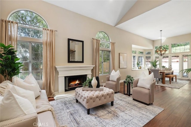 26752 Devonshire Rd, Laguna Hills, CA 92653 - living area featuring hardwood / wood-style flooring, a chandelier, a glass covered fireplace, and high vaulted ceiling