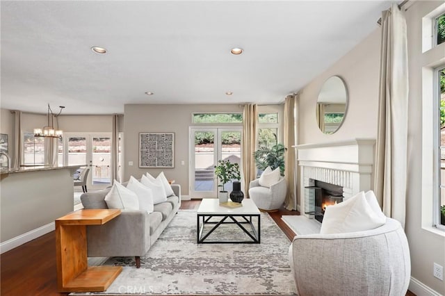 26752 Devonshire Rd, Laguna Hills, CA 92653 - living area featuring healthy amount of natural light, a brick fireplace, wood finished floors, a chandelier, and recessed lighting