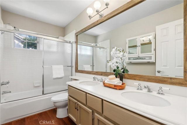 26752 Devonshire Rd, Laguna Hills, CA 92653 - bathroom featuring wood finished floors, toilet, double vanity, and enclosed tub / shower combo