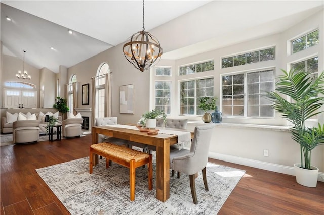 26752 Devonshire Rd, Laguna Hills, CA 92653 - dining room featuring a chandelier, high vaulted ceiling, dark wood finished floors, baseboards, and a glass covered fireplace