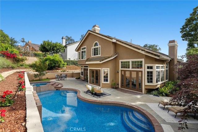 26752 Devonshire Rd, Laguna Hills, CA 92653 - back of house with french doors, stucco siding, a patio area, a pool with connected hot tub, and a chimney