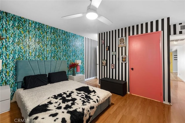15015 Sherman Way Unit 314, Van Nuys, CA 91405 - bedroom with wallpapered walls, an accent wall, light wood finished floors, a ceiling fan, and baseboards