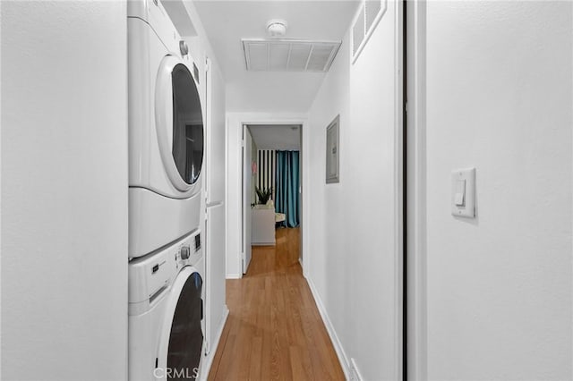 15015 Sherman Way Unit 314, Van Nuys, CA 91405 - clothes washing area with stacked washing machine and dryer, light wood finished floors, and baseboards