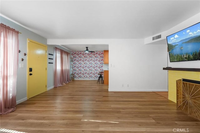 15015 Sherman Way Unit 314, Van Nuys, CA 91405 - unfurnished living room with light wood finished floors, baseboards, a fireplace, and wallpapered walls