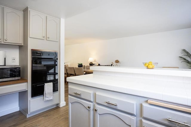 2506 Woodlands Way, Oceanside, CA 92054 - kitchen with stainless steel microwave, tile countertops, wood finished floors, and a warming drawer