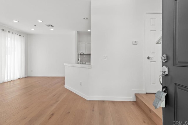 entryway with baseboards, recessed lighting, and light wood finished floors