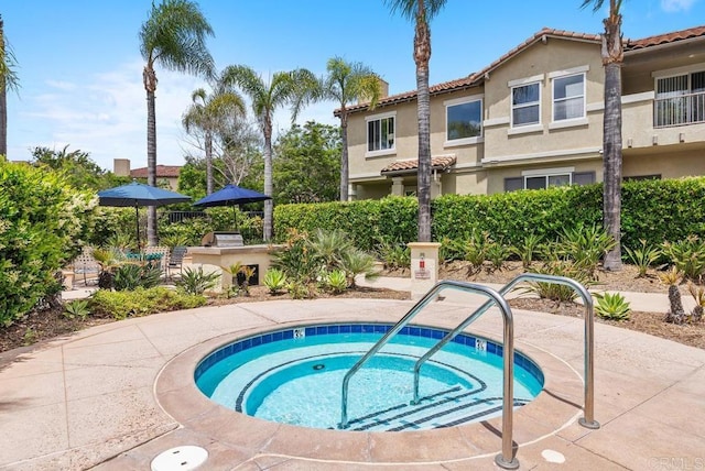 view of pool with a hot tub