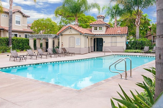community pool featuring a pergola, fence, and a patio area