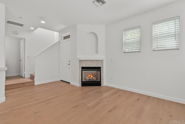 6180 Citracado Cir, Carlsbad, CA 92009 - unfurnished living room with light wood-style floors, a fireplace, stairs, and recessed lighting