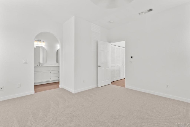 6180 Citracado Cir, Carlsbad, CA 92009 - unfurnished bedroom featuring light colored carpet, arched walkways, and ensuite bath