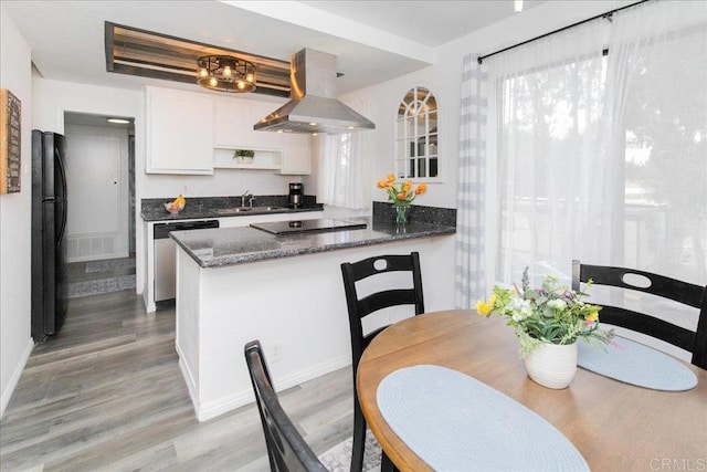 2157 Arnold Way Unit 821, Alpine, CA 91901 - kitchen with island range hood, black appliances, light wood finished floors, white cabinetry, and a peninsula