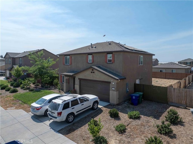 2045 Conadria Ave, Chowchilla, CA 93610 - view of front of house featuring stucco siding, fence, an attached garage, and a residential view