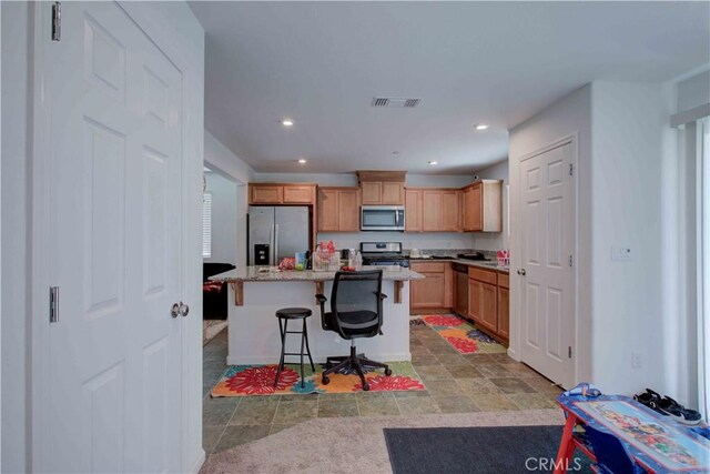 2045 Conadria Ave, Chowchilla, CA 93610 - kitchen with stainless steel appliances, a breakfast bar area, a kitchen island, recessed lighting, and light stone countertops