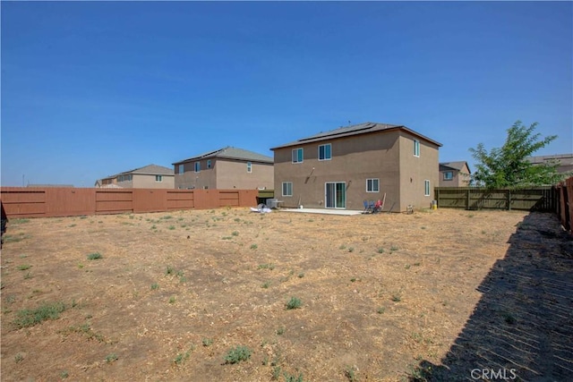 2045 Conadria Ave, Chowchilla, CA 93610 - rear view of property featuring a fenced backyard, roof mounted solar panels, and stucco siding