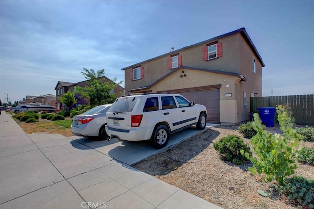 2045 Conadria Ave, Chowchilla, CA 93610 - view of front of house featuring fence, driveway, stucco siding, and an attached garage