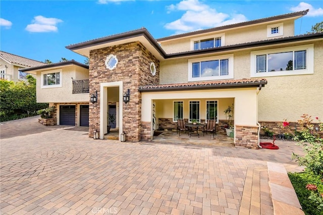19151 Fowler Ave, North Tustin, CA 92705 - view of front of property featuring stucco siding, stone siding, an attached garage, decorative driveway, and a patio