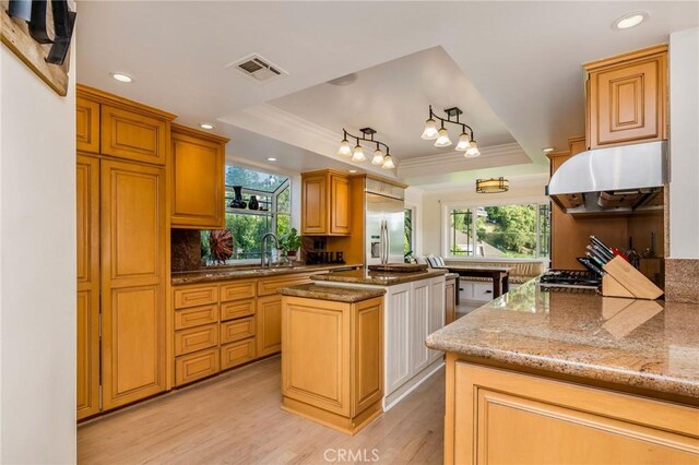 19151 Fowler Ave, North Tustin, CA 92705 - kitchen featuring under cabinet range hood, a tray ceiling, stainless steel built in refrigerator, crown molding, and light wood-style floors