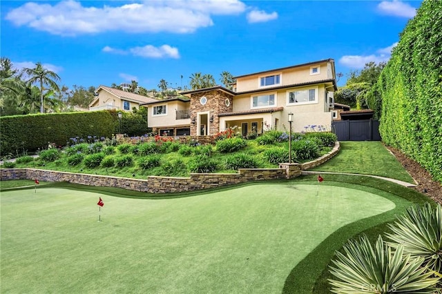 19151 Fowler Ave, North Tustin, CA 92705 - back of house with stucco siding, a fenced backyard, a putting green, and stone siding