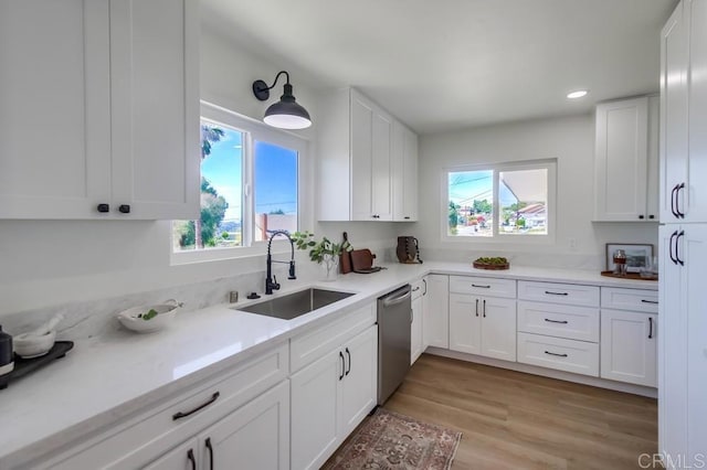 kitchen featuring a sink, dishwasher, plenty of natural light, white cabinetry, and recessed lighting