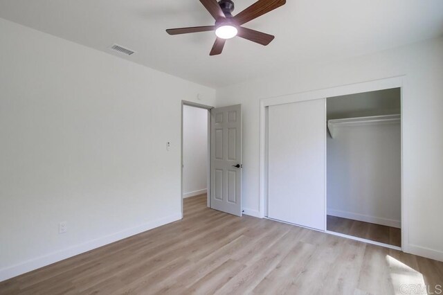 unfurnished bedroom with wood finished floors, baseboards, a closet, and a ceiling fan