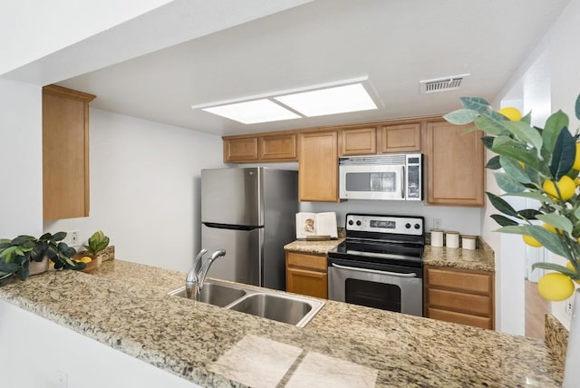 14936 Avenida Venusto Unit 12, San Diego, CA 92128 - kitchen featuring stainless steel appliances, a sink, a peninsula, and light stone countertops