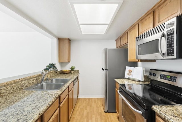 14936 Avenida Venusto Unit 12, San Diego, CA 92128 - kitchen featuring stainless steel appliances, a sink, light wood-type flooring, brown cabinets, and baseboards
