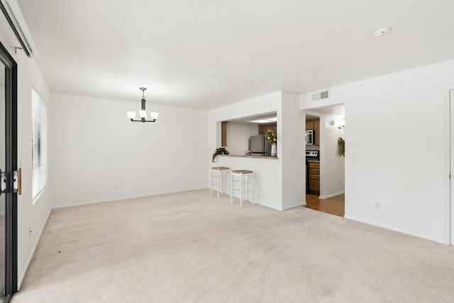 14936 Avenida Venusto Unit 12, San Diego, CA 92128 - unfurnished living room with carpet, a chandelier, and baseboards
