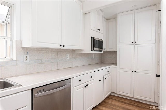 15821 Willett Ln, Huntington Beach, CA 92647 - kitchen with appliances with stainless steel finishes, white cabinets, light countertops, and decorative backsplash