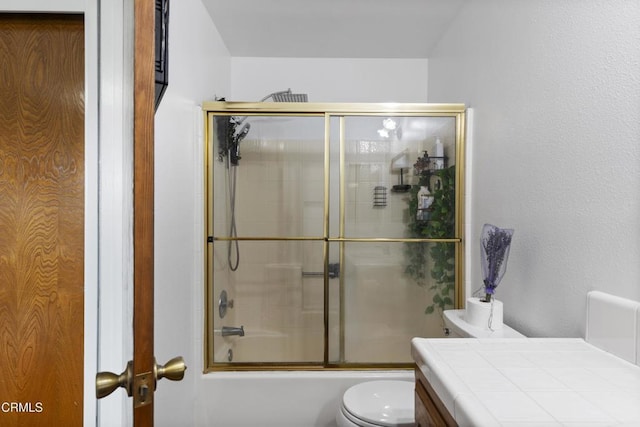 full bathroom featuring toilet, enclosed tub / shower combo, and vanity