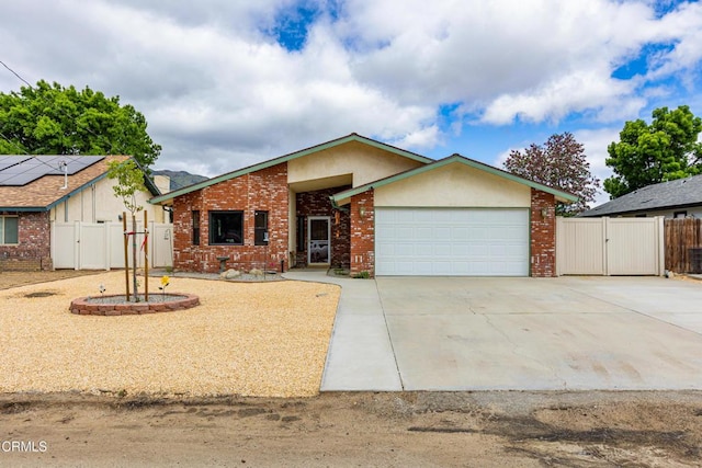 view of front of house with a gate, a garage, concrete driveway, and fence